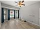 Bedroom featuring wood-look flooring, modern gray walls, and large windows with view of pool and backyard at 3939 Sunset Lake Dr, Lakeland, FL 33810