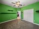 Bedroom with green walls, ceiling fan, carpet flooring, closet, and view to the kitchen at 3939 Sunset Lake Dr, Lakeland, FL 33810