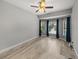 Bedroom featuring wood-look flooring, modern gray walls, and large windows with view of pool and backyard at 3939 Sunset Lake Dr, Lakeland, FL 33810