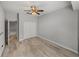 Bedroom featuring wood-look flooring, modern gray walls, a ceiling fan, closet, and doorway at 3939 Sunset Lake Dr, Lakeland, FL 33810