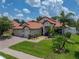 Charming home featuring a three-car garage, lush landscaping, and a brick paved driveway at 3939 Sunset Lake Dr, Lakeland, FL 33810