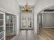 Bright foyer features decorative glass doors, chandelier, and tiled floors throughout at 3939 Sunset Lake Dr, Lakeland, FL 33810