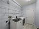 Functional laundry room with white washer and dryer units, wire rack storage, and tile flooring at 3939 Sunset Lake Dr, Lakeland, FL 33810