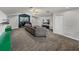 Spacious living room featuring carpeted floors, neutral gray walls, desk area, large TV, and comfortable couch at 3939 Sunset Lake Dr, Lakeland, FL 33810