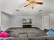 Spacious living room featuring plush gray carpeting, a ceiling fan, and a media center under the wall-mounted TV at 3939 Sunset Lake Dr, Lakeland, FL 33810