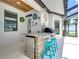 Outdoor kitchen area with a built-in grill, sink, stainless fridge, and seating, ideal for poolside entertaining and dining at 3939 Sunset Lake Dr, Lakeland, FL 33810