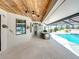 Charming outdoor patio with a wood ceiling, complete with a built-in kitchen, tile flooring, and a screened-in pool area at 3939 Sunset Lake Dr, Lakeland, FL 33810