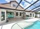Outdoor patio with a pool, featuring a built-in kitchen, tile flooring, and a screened enclosure, perfect for entertaining at 3939 Sunset Lake Dr, Lakeland, FL 33810