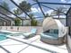 A screened-in pool area, complete with a luxurious chaise lounge and a covered daybed with plush cushions at 3939 Sunset Lake Dr, Lakeland, FL 33810