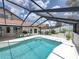 A sparkling screened-in pool boasts an outdoor kitchen with bar seating and decorative wall hangings at 3939 Sunset Lake Dr, Lakeland, FL 33810