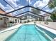 Inviting screened-in pool featuring a built-in BBQ, bar stools, and decorative accents for outdoor entertainment at 3939 Sunset Lake Dr, Lakeland, FL 33810