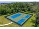 Aerial view of tennis and pickleball courts surrounded by lush greenery in a gated community at 3939 Sunset Lake Dr, Lakeland, FL 33810