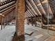 Spacious attic features exposed beams, brick chimney, and wooden floors, offering potential for renovation at 485 E Stanford St, Bartow, FL 33830