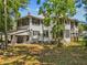 Rear view of the house with a carport and multiple windows, surrounded by lush greenery at 485 E Stanford St, Bartow, FL 33830