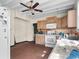 Angle of the kitchen featuring white appliances, brick floors, and wooden cabinets at 485 E Stanford St, Bartow, FL 33830