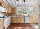 View of the kitchen featuring wooden cabinets, white appliances and brick floors at 485 E Stanford St, Bartow, FL 33830