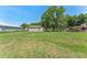 Large grassy area with an outbuilding surrounded by mature trees, ideal for development at 652 N Jackson St, Eagle Lake, FL 33839