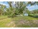 Spacious backyard with green grass, mature trees, and a small shed, providing a serene outdoor setting at 728 Trenton Rd, Lakeland, FL 33815
