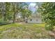 Green backyard featuring a well-maintained lawn and a quaint white home with a covered outdoor space at 728 Trenton Rd, Lakeland, FL 33815