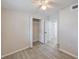 Well-lit room featuring gray laminate flooring, a ceiling fan, closet, and doors to other rooms at 728 Trenton Rd, Lakeland, FL 33815