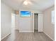 Clean bedroom featuring gray laminate flooring, a ceiling fan, closet, and doors to other rooms at 728 Trenton Rd, Lakeland, FL 33815