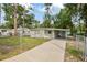 Cozy one-story home with a covered carport, front lawn, and chain link fence for added security at 728 Trenton Rd, Lakeland, FL 33815