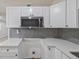 A detailed view of a well-lit kitchen features white cabinetry, countertops, and stainless steel microwave at 728 Trenton Rd, Lakeland, FL 33815