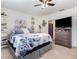 Comfortable bedroom with a ceiling fan, dresser, and decor, with a view into an ensuite bathroom at 3333 Costello Cir, Winter Haven, FL 33884