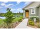 Inviting home exterior with a yellow door, lush landscaping, and a serene lake backdrop at 3333 Costello Cir, Winter Haven, FL 33884