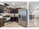 Modern kitchen featuring stainless steel appliances, dark cabinetry, and tile flooring, adjacent to the dining area at 3333 Costello Cir, Winter Haven, FL 33884