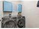 Convenient laundry room with front-load washer and dryer and blue cabinets for storage at 3333 Costello Cir, Winter Haven, FL 33884