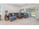 Cozy living room featuring a sectional sofa and a sliding glass door to the outdoor pool area at 3333 Costello Cir, Winter Haven, FL 33884