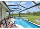 Sparkling pool with screened enclosure and peaceful water view, perfect for enjoying outdoor living at 3333 Costello Cir, Winter Haven, FL 33884