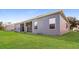 A spacious backyard view of the home, lush green lawn, and the house exterior at 4526 Ficus Tree Rd, Kissimmee, FL 34758