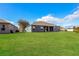 Rear view of the home with a large, green lawn at 4526 Ficus Tree Rd, Kissimmee, FL 34758