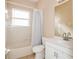 Neutral bathroom featuring a white vanity with a sink, toilet, tub, and shower with tile surround at 4526 Ficus Tree Rd, Kissimmee, FL 34758