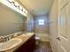 Bright bathroom featuring a double sink vanity, a bathtub, and neutral tile at 6376 Sw 117Th Street Rd, Ocala, FL 34476