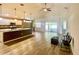 Open-concept living space features hardwood floors, a ceiling fan, and sliding glass doors at 6376 Sw 117Th Street Rd, Ocala, FL 34476