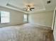 Spacious main bedroom with plush carpeting and tray ceiling is bathed in natural light at 6376 Sw 117Th Street Rd, Ocala, FL 34476