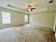 Spacious main bedroom with plush carpeting and tray ceiling is bathed in natural light at 6376 Sw 117Th Street Rd, Ocala, FL 34476