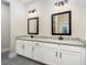 Bathroom featuring a double vanity with granite countertops, dual sinks, and modern black fixtures at 7661 Somersworth Dr, Kissimmee, FL 34747