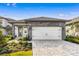 Charming single-Gathering home with a stone-accented facade and a brick paver driveway leading to a two-car garage at 7661 Somersworth Dr, Kissimmee, FL 34747