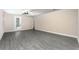 Bright living room with gray wood flooring and a sliding glass door leading to the backyard at 7661 Somersworth Dr, Kissimmee, FL 34747