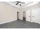 Spacious main bedroom with a tray ceiling, ceiling fan, gray wood floors, and multiple doors at 7661 Somersworth Dr, Kissimmee, FL 34747