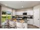 Bright kitchen with a center island with bar seating, white cabinetry, and stainless steel appliances, seamlessly connecting to outdoor views at 774 Ambleside Ave, Haines City, FL 33844