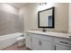Bathroom featuring granite countertop, modern fixtures, and a tub with tile surround at 7890 Somersworth Dr, Kissimmee, FL 34747
