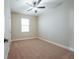 Bright bedroom featuring neutral carpet, a ceiling fan, and large window at 7890 Somersworth Dr, Kissimmee, FL 34747