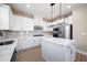 Bright kitchen with white cabinets, stainless appliances, stylish light fixture, and center island at 7890 Somersworth Dr, Kissimmee, FL 34747