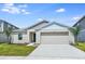 Charming single-story home with a two-car garage, manicured lawn, and lush landscaping at 1050 Foreshore Ln, Haines City, FL 33844