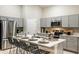 Modern kitchen with stainless steel appliances, gray cabinets, quartz countertops and island with seating at 1050 Foreshore Ln, Haines City, FL 33844